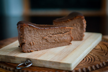 Burnt chocolate cheesecake on brown wooden background. selective focus