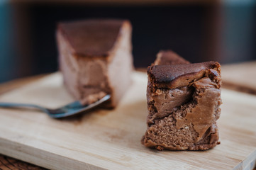 Burnt chocolate cheesecake on brown wooden background. selective focus