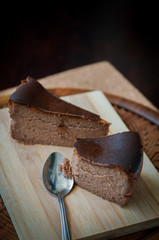 Burnt chocolate cheesecake on brown wooden background. selective focus