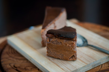 Burnt chocolate cheesecake on brown wooden background. selective focus