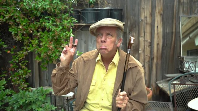 Retired old man with dementia making crazy gestures with his hands, and is then handed a prescription pill bottle.