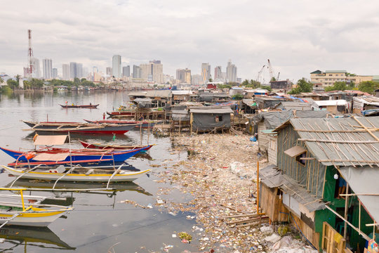 Manila slums on the background of a big city. Houses and boats of the poor inhabitants of Manila. Dwelling poor in the Philippines.