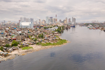 The urban landscape of Manila, with slums and skyscrapers. Sea port and residential areas. The contrast of poor and rich areas. The capital of the Philippines, view from above.