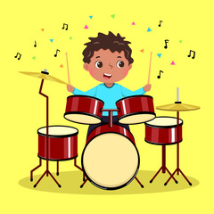 Cute boy playing the drum on yellow background