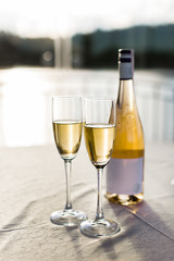 Romantic luxury evening with pair glass of champagne and bottle. Two romantic glasses of sparkling champagne alongside a bottle in luxury copy space to celebrate a wedding, anniversary, New Year