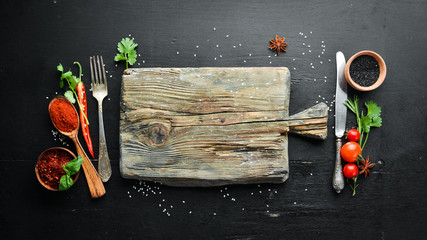 The background of cooking. On a black wooden background. Top view. Free space for your text.