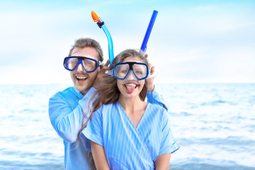 Happy young couple with snorkeling masks at sea resort