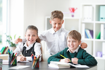 Cute little children doing lessons in classroom