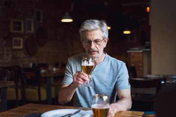 Senior man having a beer in the bar