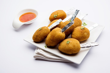 Crispy Veg lollipop recipe made using boiled potato with spices covered with corn flour and bread crumbs coating and then deep fried, served with toothpick or ice cream stock inserted in it with sauce