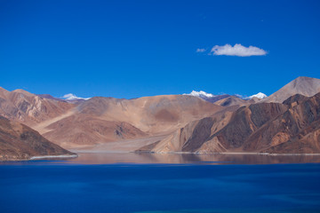 Fototapeta na wymiar View of majestic rocky mountains against the blue sky and lake Pangong in Indian Himalayas, Ladakh region, India. Nature and travel concept