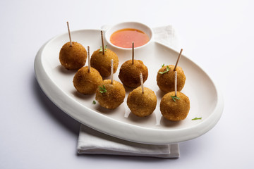 Crispy Veg lollipop recipe made using boiled potato with spices covered with corn flour and bread crumbs coating and then deep fried, served with toothpick or ice cream stock inserted in it with sauce
