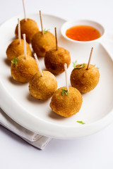 Crispy Veg lollipop recipe made using boiled potato with spices covered with corn flour and bread crumbs coating and then deep fried, served with toothpick or ice cream stock inserted in it with sauce