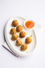 Crispy Veg lollipop recipe made using boiled potato with spices covered with corn flour and bread crumbs coating and then deep fried, served with toothpick or ice cream stock inserted in it with sauce
