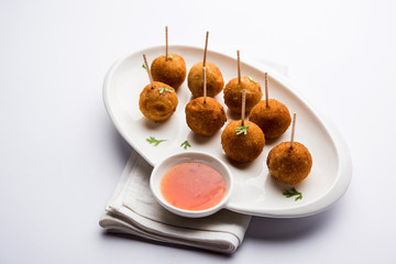 Crispy Veg lollipop recipe made using boiled potato with spices covered with corn flour and bread crumbs coating and then deep fried, served with toothpick or ice cream stock inserted in it with sauce