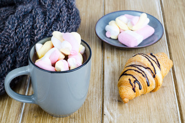 Cup of hot cocoa with marshmallows, woolen warm scarf, cozy winter evening