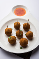 Crispy Veg lollipop recipe made using boiled potato with spices covered with corn flour and bread crumbs coating and then deep fried, served with toothpick or ice cream stock inserted in it with sauce