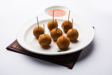 Crispy Veg lollipop recipe made using boiled potato with spices covered with corn flour and bread crumbs coating and then deep fried, served with toothpick or ice cream stock inserted in it with sauce