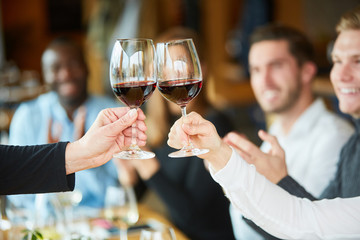 Friends celebrate and toast with red wine