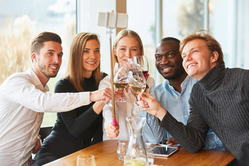 Young people in the restaurant toast with wine