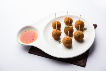 Crispy Veg lollipop recipe made using boiled potato with spices covered with corn flour and bread crumbs coating and then deep fried, served with toothpick or ice cream stock inserted in it with sauce