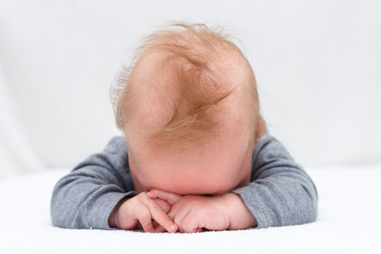 Sleeping Newborn Baby On A Blanket. Infant Boy With Hands Over His Head