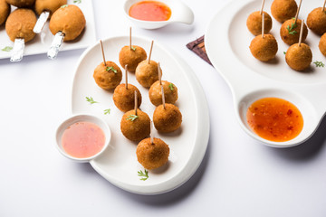 Crispy Veg lollipop recipe made using boiled potato with spices covered with corn flour and bread crumbs coating and then deep fried, served with toothpick or ice cream stock inserted in it with sauce