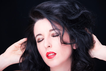 Fototapeta premium Young attractive woman with long black hair on dark background