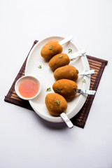 Crispy Veg lollipop recipe made using boiled potato with spices covered with corn flour and bread crumbs coating and then deep fried, served with toothpick or ice cream stock inserted in it with sauce