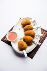 Crispy Veg lollipop recipe made using boiled potato with spices covered with corn flour and bread crumbs coating and then deep fried, served with toothpick or ice cream stock inserted in it with sauce