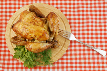 Grilled chicken on cutting board on red tablecloth background