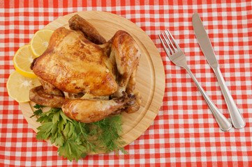 Grilled chicken on cutting board on tablecloth background