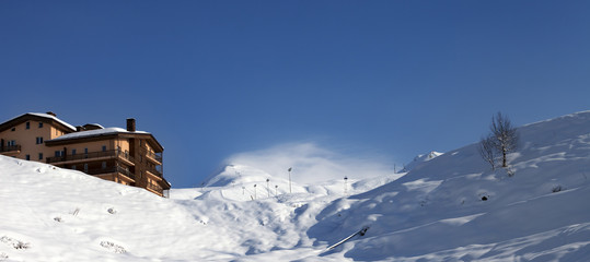 Off-piste slope and hotel in winter mountains