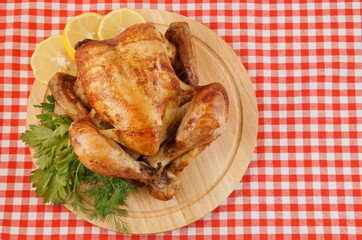Grilled chicken on cutting board on tablecloth background
