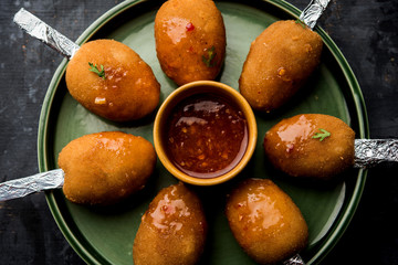Crispy Veg lollipop recipe made using boiled potato with spices covered with corn flour and bread crumbs coating and then deep fried, served with toothpick or ice cream stock inserted in it with sauce