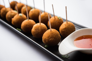 Crispy Veg lollipop recipe made using boiled potato with spices covered with corn flour and bread crumbs coating and then deep fried, served with toothpick or ice cream stock inserted in it with sauce