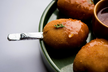 Crispy Veg lollipop recipe made using boiled potato with spices covered with corn flour and bread crumbs coating and then deep fried, served with toothpick or ice cream stock inserted in it with sauce