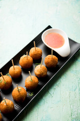 Crispy Veg lollipop recipe made using boiled potato with spices covered with corn flour and bread crumbs coating and then deep fried, served with toothpick or ice cream stock inserted in it with sauce