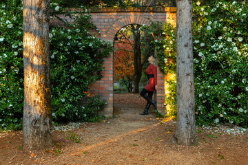 Fototapeta na wymiar Woman standing in beautiful stone garden arch