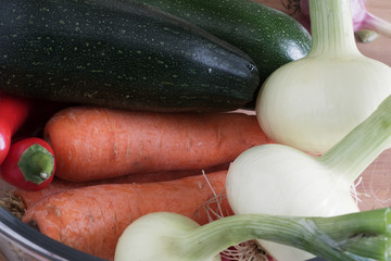 autumn harvest, carrots and onions lie near courgette and chilli, vegetables close-up,