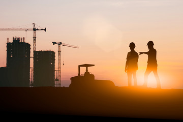 Silhouette of engineer and construction team working at site over blurred background for industry background with Light fair.Create from multiple reference images together