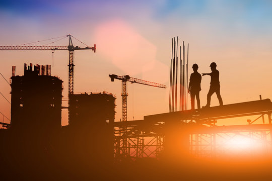 Silhouette of engineer and construction team working at site over blurred background for industry background with Light fair.Create from multiple reference images together