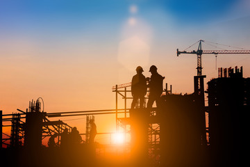Silhouette of engineer and construction team working at site over blurred background for industry background with Light fair.Create from multiple reference images together