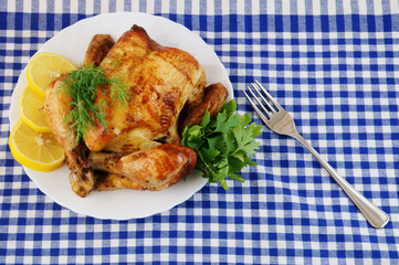 Grilled chicken in white plate on blue tablecloth
