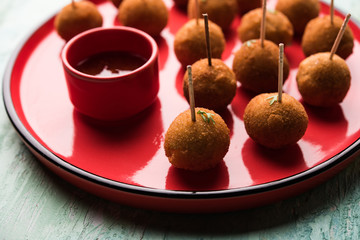 Crispy Veg lollipop recipe made using boiled potato with spices covered with corn flour and bread crumbs coating and then deep fried, served with toothpick or ice cream stock inserted in it with sauce