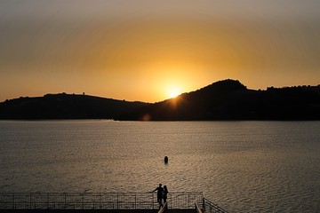 para o zachodzie słońca na plaży nad jeziorem, widok na góry