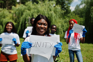 Group of happy african volunteers hold blank board with unity sign in park. Africa volunteering,...