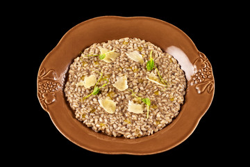 Plate of italian risotto with tuffle cream and parmesan isolated at black background.