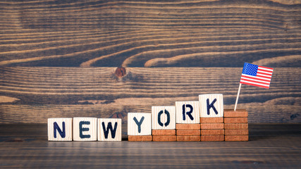 New York, United States. Politics, economic and immigration concept. Wooden letters and flag on the office desk