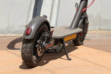 Electric scooter on a parking lot. City bike rental system, public scooter on a summer street